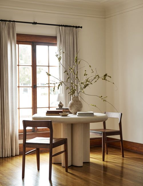 a table with two chairs and a vase on it