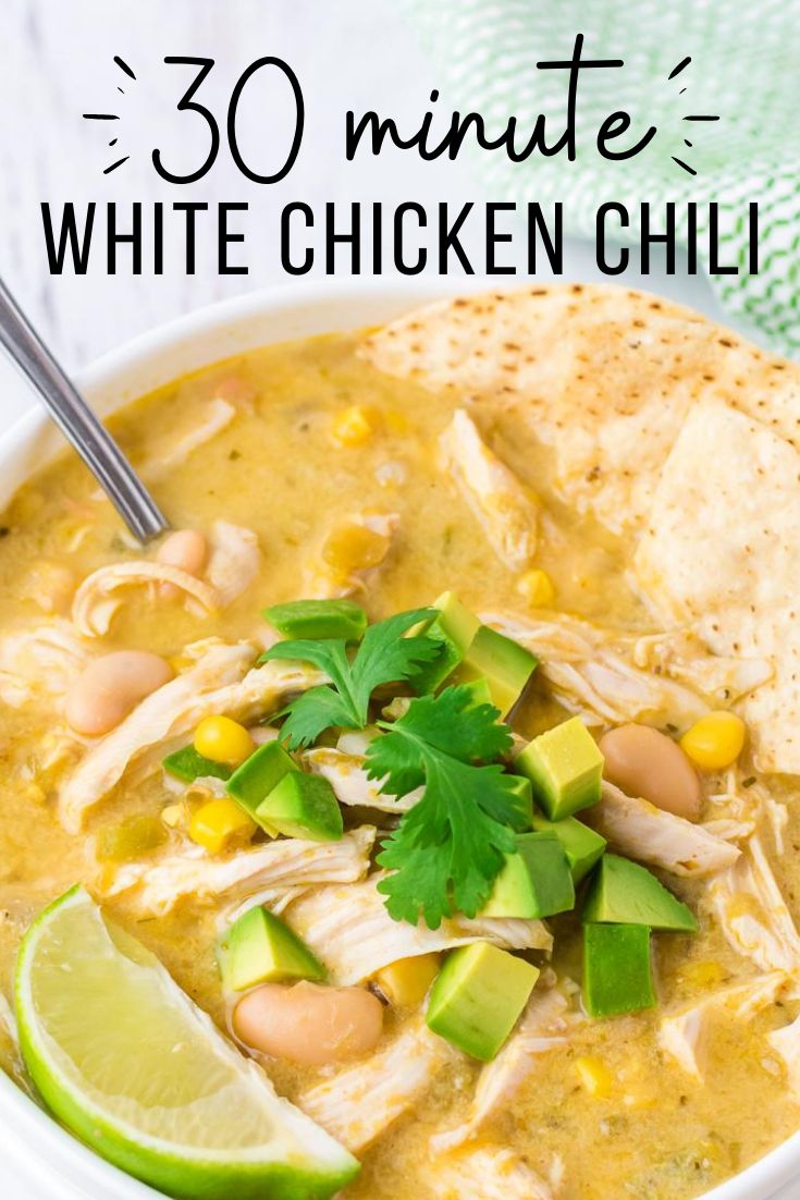 white chicken chili in a bowl with limes and cilantro on the side