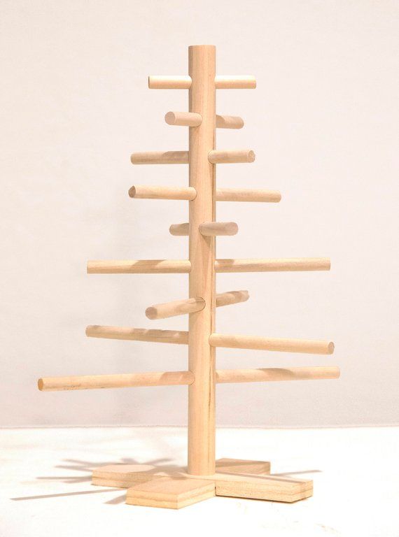 a wooden christmas tree on a stand with no ornaments or decorations in the bottom half