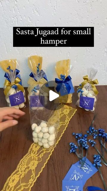 the table is set up with blue and white flowers, ribbons, and small bags