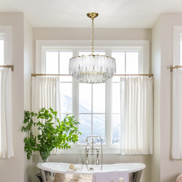 a bathroom with a claw foot tub and chandelier