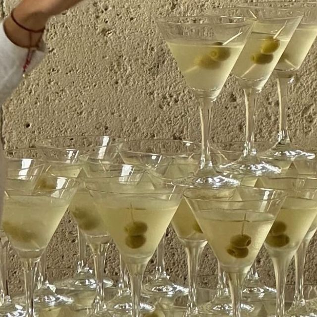 several martini glasses filled with white wine and olives