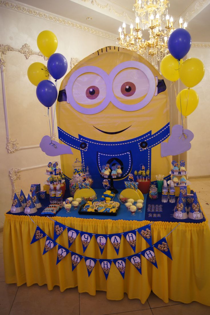 a table with balloons and decorations for a despicable minion themed birthday party