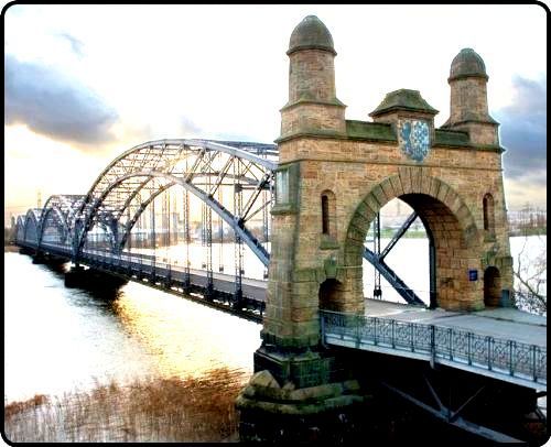 an old bridge over the water with a clock on it