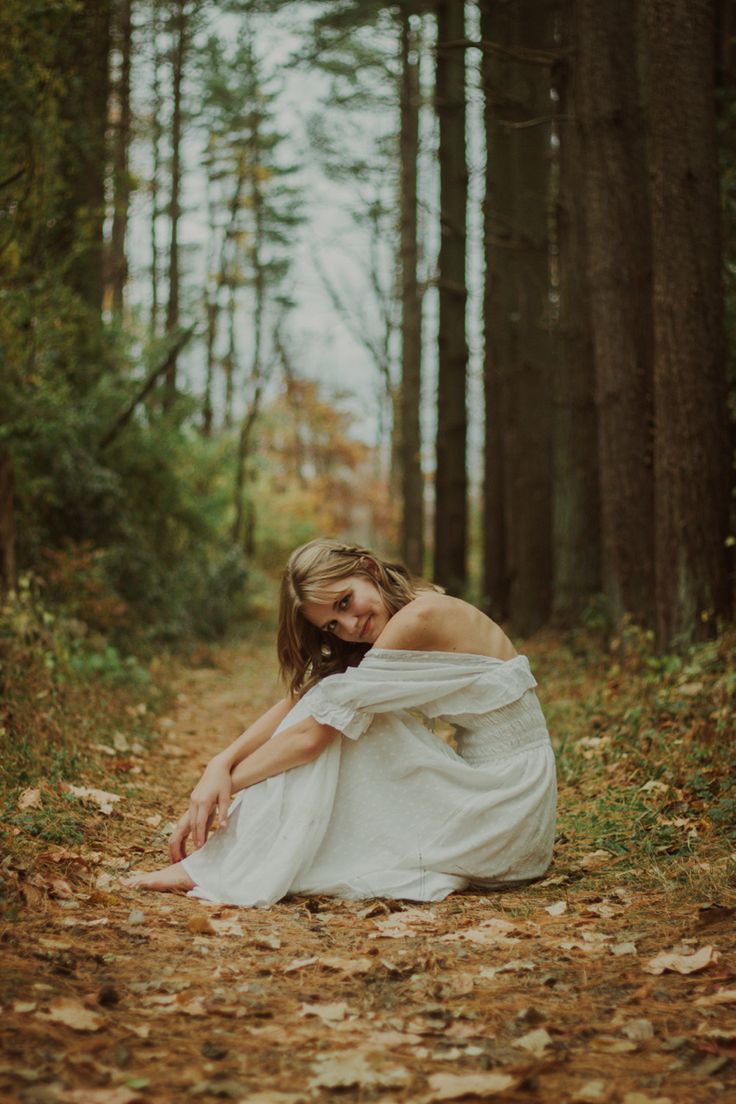 a woman in white dress sitting on the ground