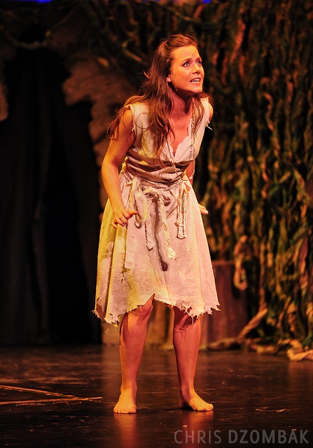 a woman in a costume standing on a stage