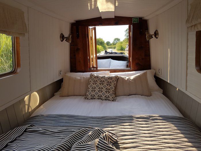 there is a bed in the room with pillows on it and a window over the bed