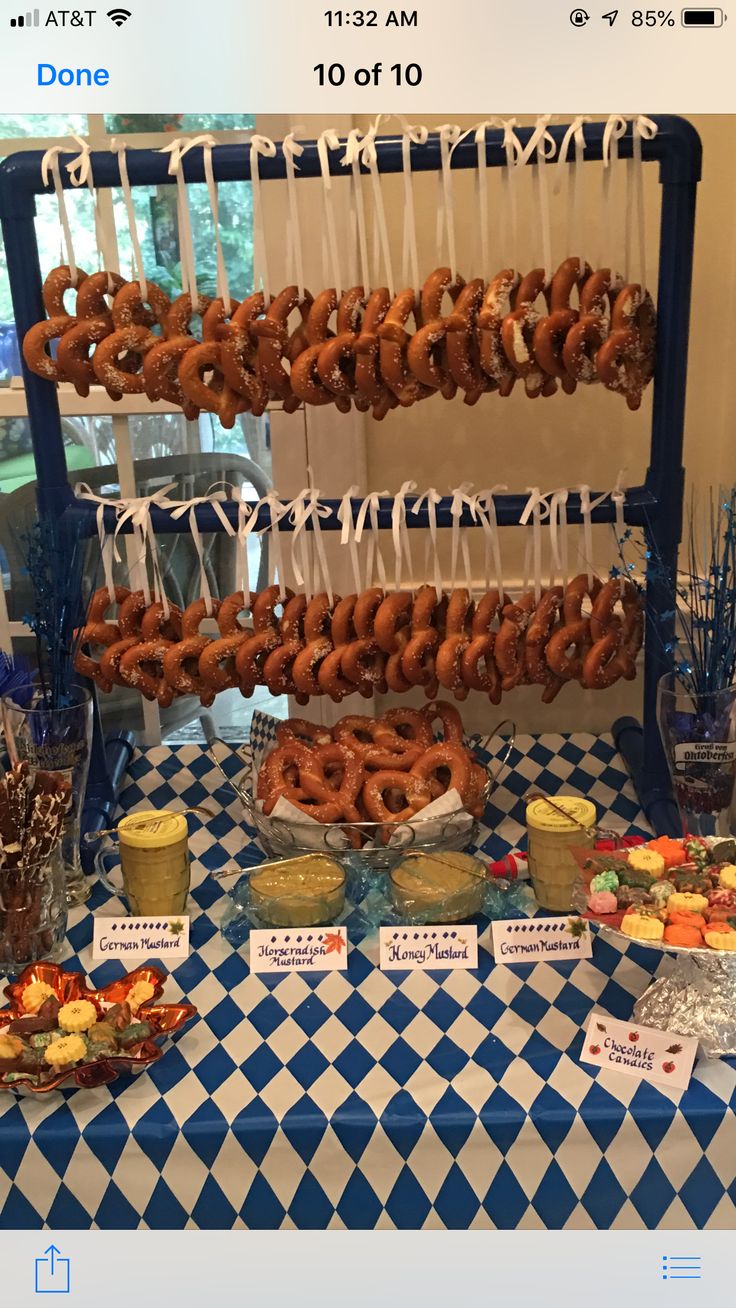 a table topped with lots of donuts and desserts on top of it's blue and white checkered cloth