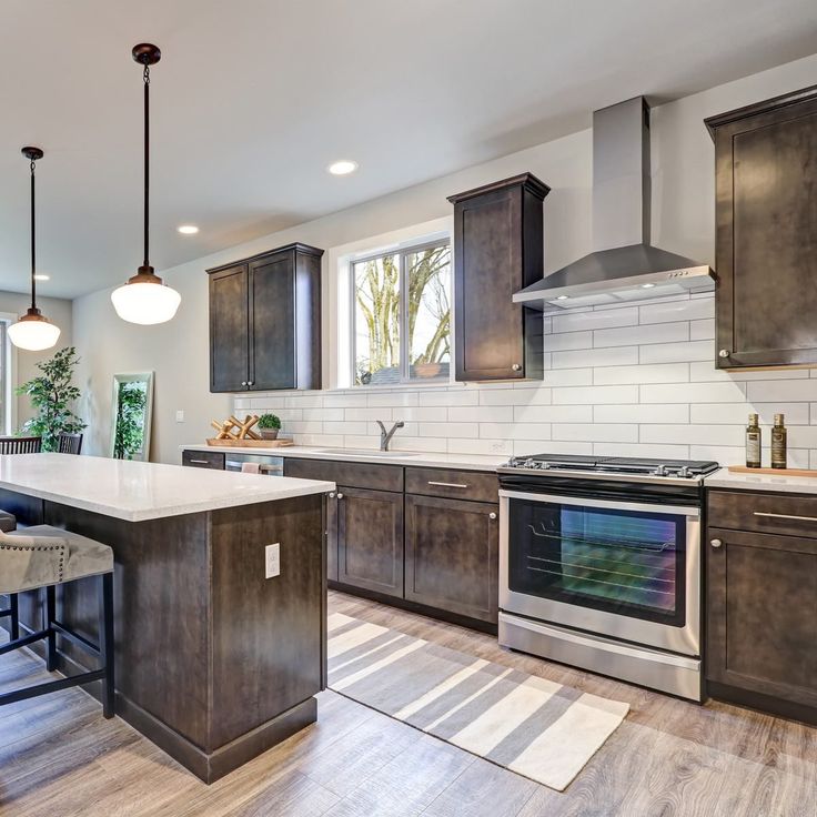 a large kitchen with an island and stainless steel appliances