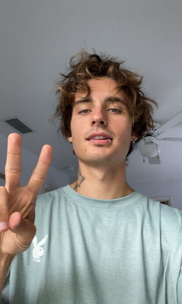 a young man making the peace sign with his fingers