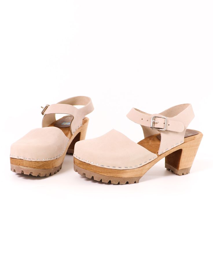 The Abba by MIA is an authentic Swedish Clog, handmade in Sweden from the finest Swedish wood and Italian leather. With an adjustable buckle strap and a 3" solid heel, this 70's throwback shoe is definitely a bestseller for a reason. We love these shoes for being a year-round staple. Whether you wear them with a flowy floral sundress or a wide leg palazzo pant, there is nothing that these shoes won't match. Genuine Leather l Solid Wood Sole l Adjustable Buckle l Runs Small, we suggest to size up Wooden Clogs With Stacked Heel And Round Toe, Wooden Closed Toe Clogs With Stacked Heel, Wooden Clogs With Stacked Heel And Closed Toe, Wooden Clogs With Stacked Heel For Spring, Adjustable Round Toe Clogs With Rubber Sole, Adjustable Clogs With Rubber Sole And Round Toe, Natural Clogs With Wooden Heel And Open Back, Leather Clogs With Wooden Heel In Natural Wood Color, Adjustable Round Toe Clogs