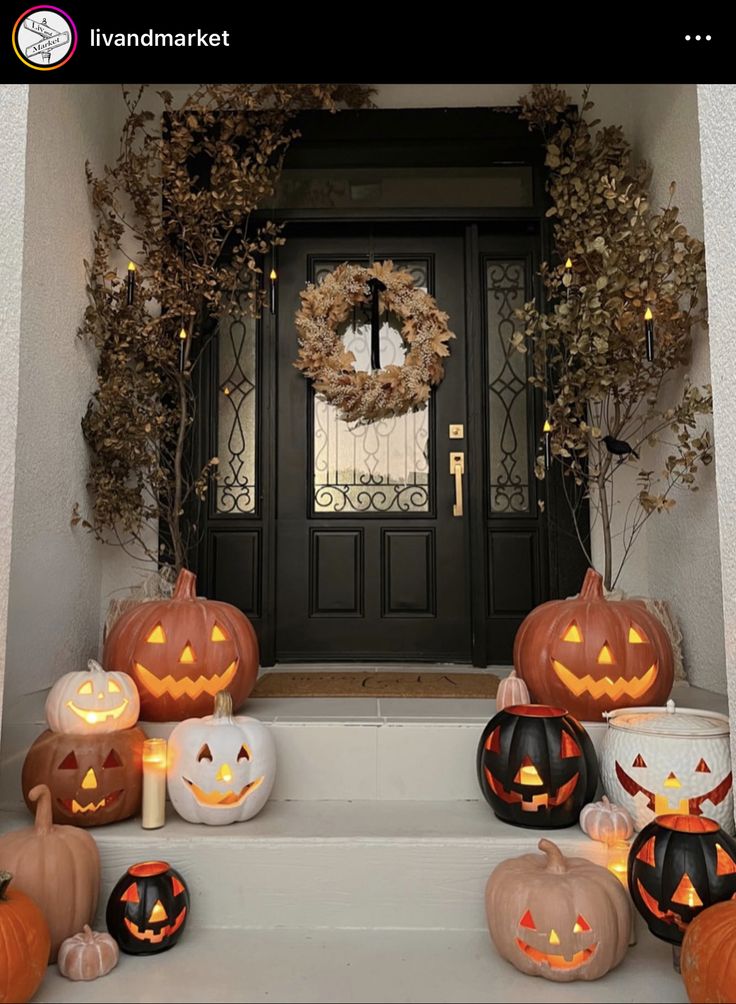 pumpkins and candles are on the steps in front of a door decorated for halloween