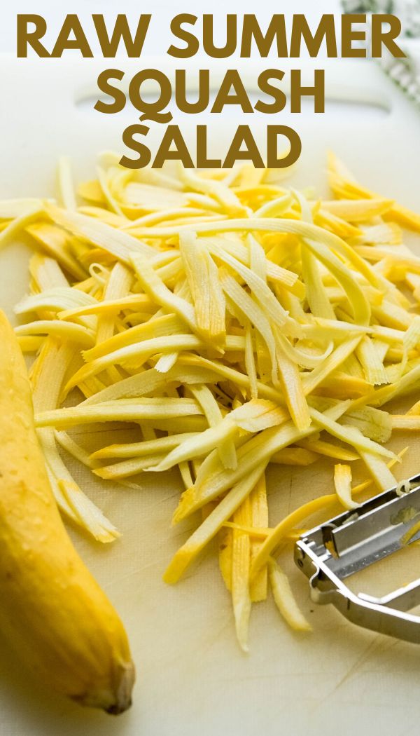 raw summer squash salad on a cutting board with a banana and grater next to it