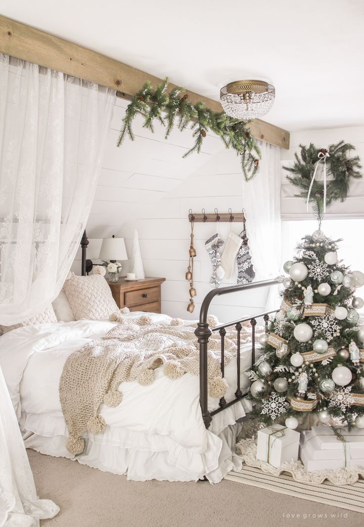 a bedroom decorated for christmas with white and silver decorations