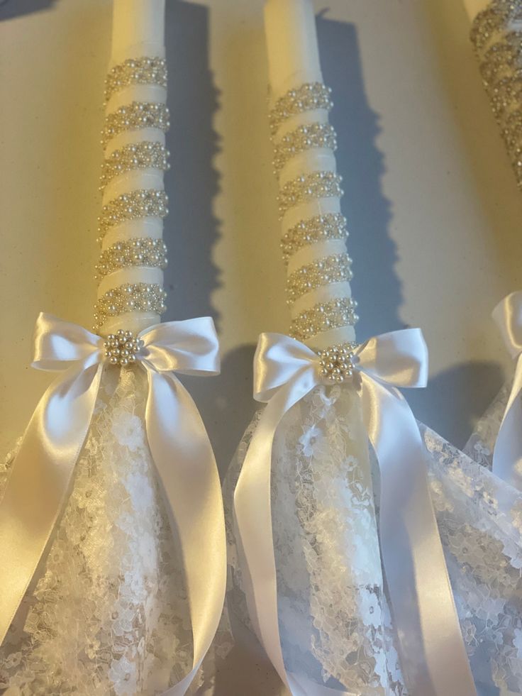 three white wedding garters with bows on them