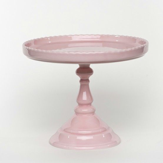 a pink cake plate sitting on top of a table