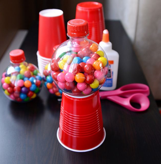 there is a candy dispenser with gumballs in it on the table