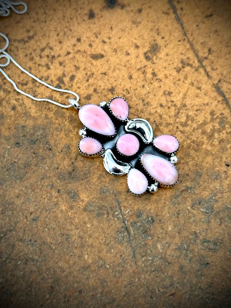 This one is exceptional. A 7 stone pendant with pink conch stones. What an attention grabber we have here. Pair it with something turquoise or wear it by itself. I will look great no matter what. Comes on an 18" chain. Pink Sterling Silver Pendant Jewelry, Pink Sterling Silver Round Pendant Necklace, Pink Sterling Silver Necklace With Round Pendant, Pink Sterling Silver Round Pendant Necklaces, Unique Pink Jewelry With Stones, Pink Spiritual Round Pendant Jewelry, Spiritual Pink Round Pendant Jewelry, Pink Sterling Silver Flower Pendant Jewelry, Pink Sterling Silver Flower Pendant Necklace