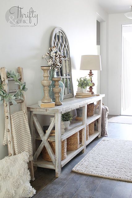 a room with a rug, table and mirror on the wall that says diy rustic x console table