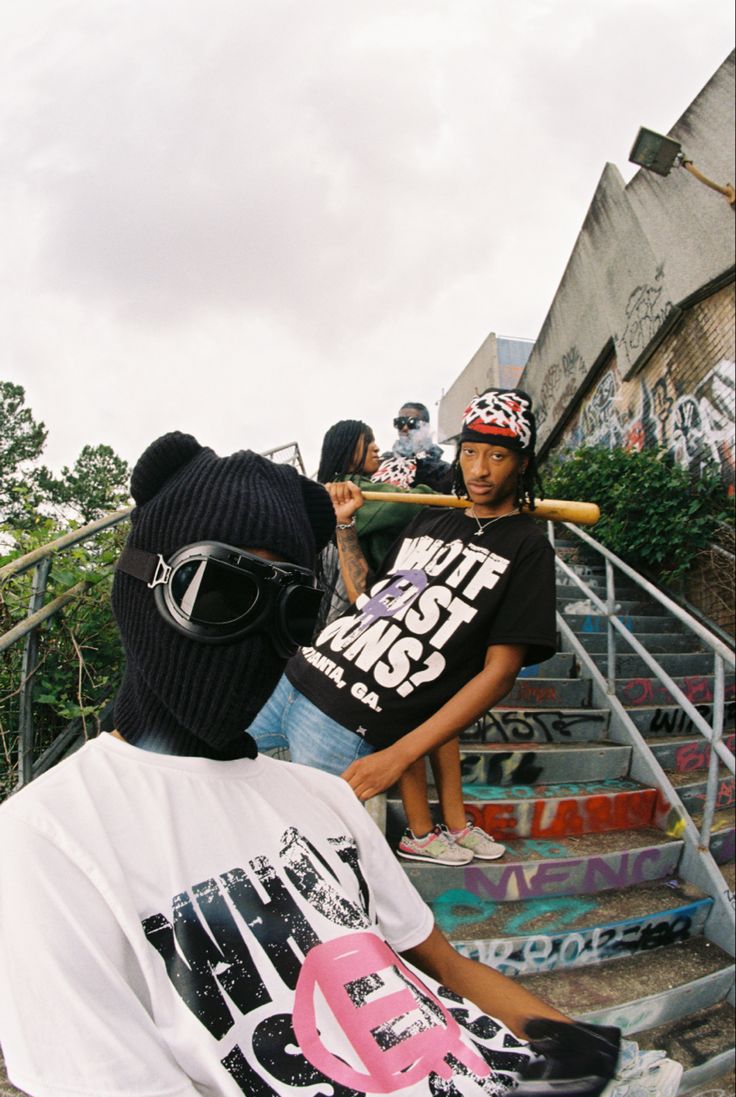 a group of young men standing next to each other in front of graffiti covered steps