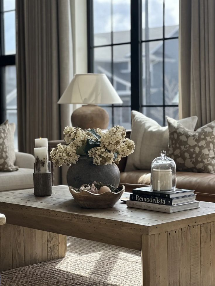 a living room filled with furniture and a large window covered in lots of natural light