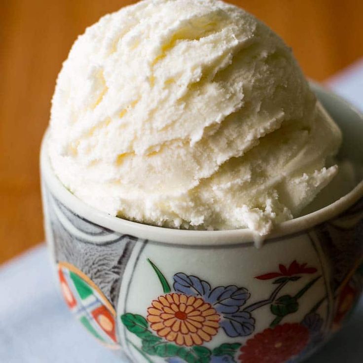 a bowl filled with ice cream sitting on top of a wooden table