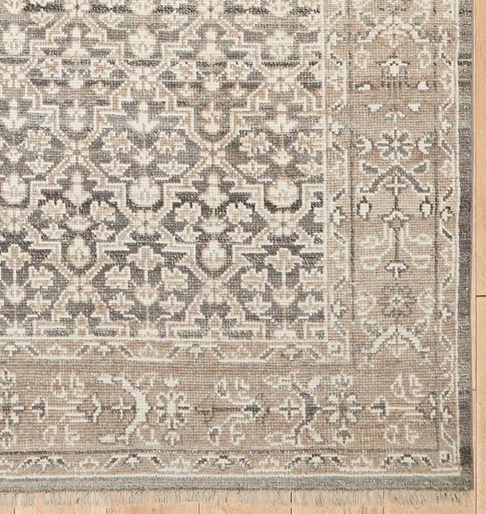 an antique rug with grey and white colors