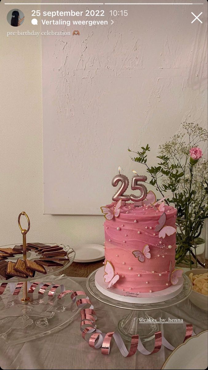 a pink cake sitting on top of a table