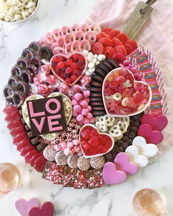 a platter filled with lots of valentine's treats and candies on top of a table