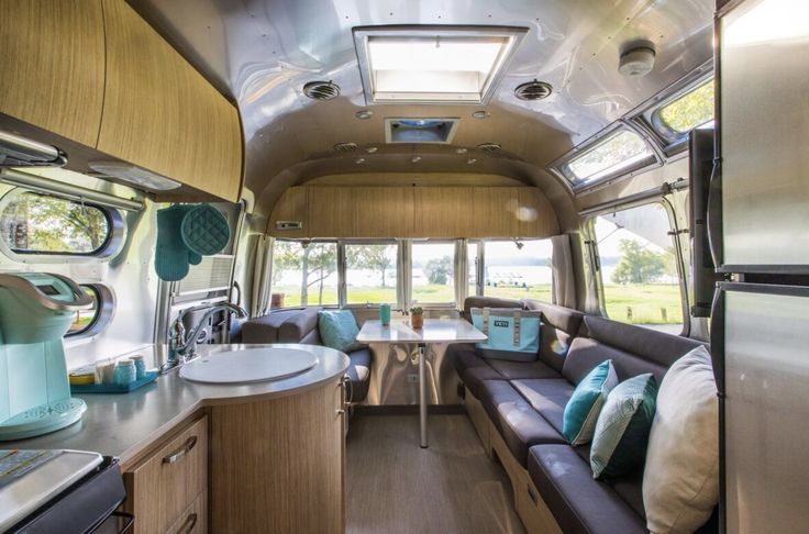 the inside of a camper with couches, tables and kitchenette in it