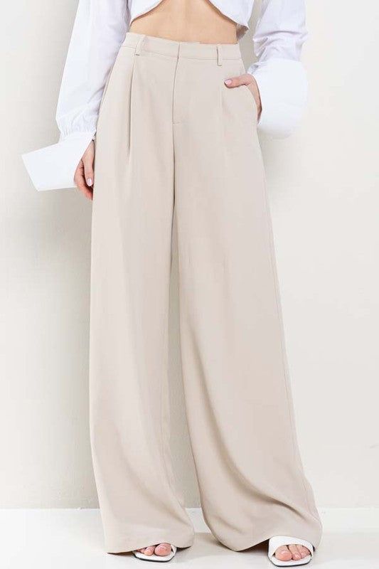 Enhance your wardrobe with our Nude Wide Leg Pants. Made with a flattering wide leg design and convenient pockets, these pants offer both style and functionality. Perfect for any occasion, these pants are a must-have for any fashion-forward individual. Elevate your look and stay on trend with these versatile and comfortable pants. Fabric & fit: 100% polyester Model is wearing size Small. Versatile Full Length Bottoms With Welt Pockets, Versatile Full-length Bottoms With Welt Pockets, Full Length Pants For Business Casual In Summer, Summer Business Casual Full Length Pants, Full Length Smart Casual Summer Pants, Full Length Business Casual Summer Pants, Chic Baggy Wide Leg Pants For Fall, Versatile Baggy Wide Leg Pants For Spring, Casual Beige Full-length Dress Pants