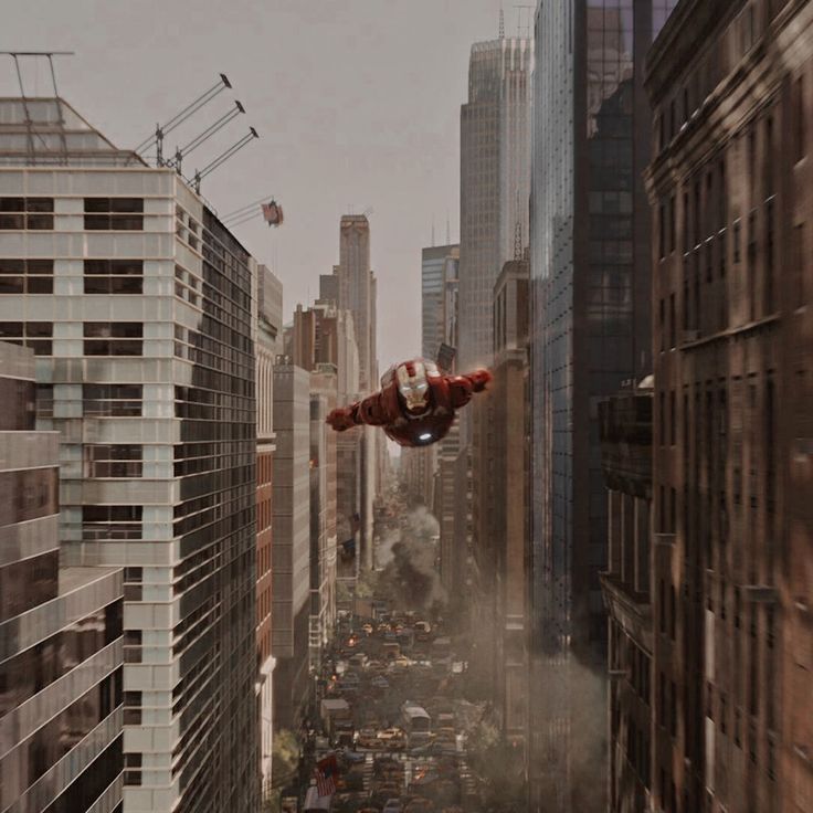 a man flying through the air while riding a skateboard in front of tall buildings