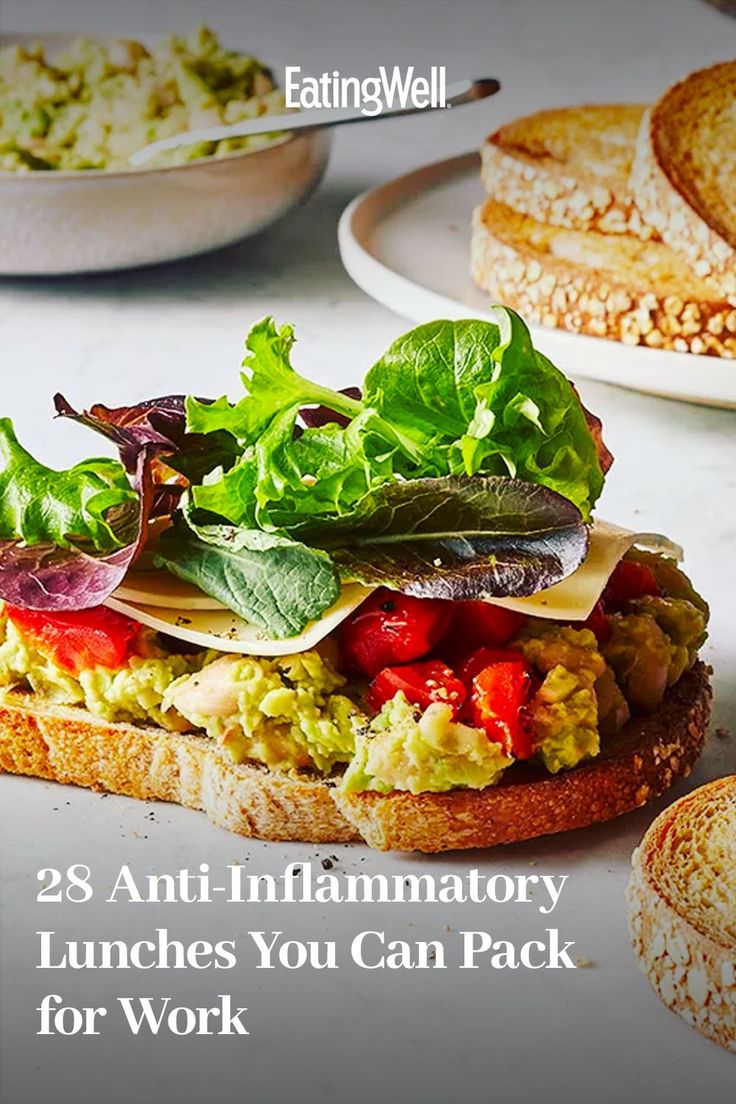 a sandwich with lettuce, tomatoes and other vegetables on it next to some bread