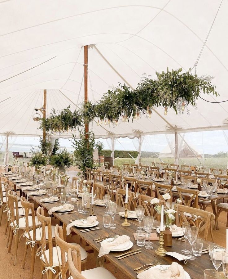 a large tent with tables and chairs set up for an outdoor wedding or reception event