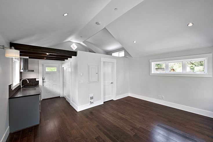 an empty room with hard wood floors and white walls