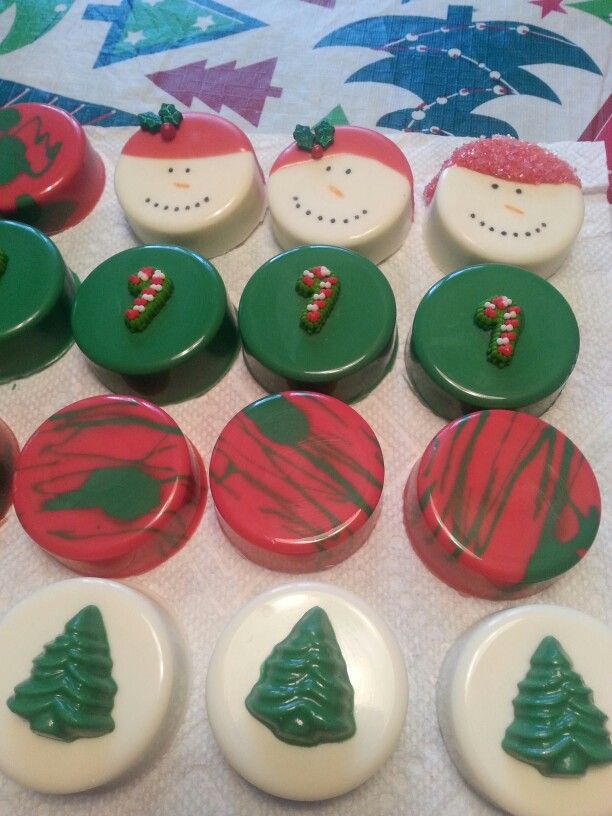 some buttons with christmas designs on them sitting on a table top next to a quilt