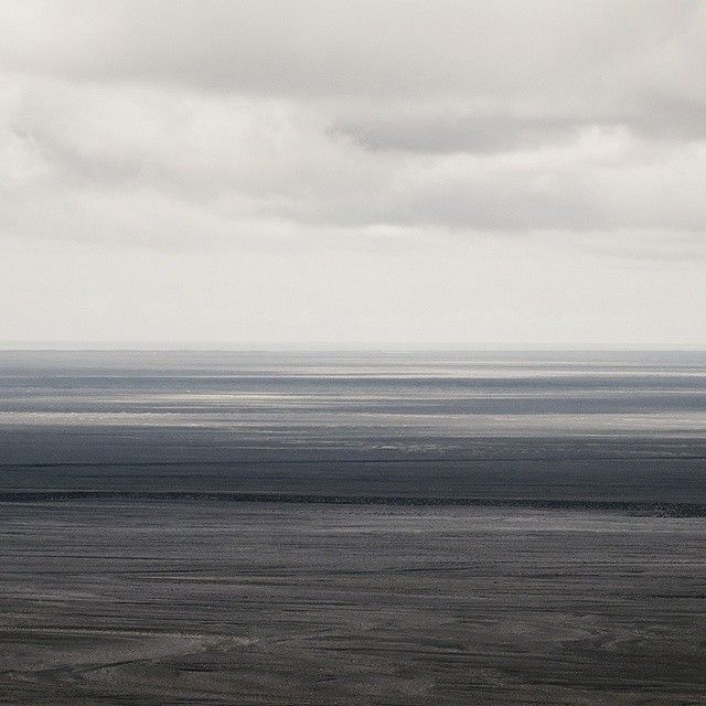 an airplane is flying over the ocean on a cloudy day with no one in it