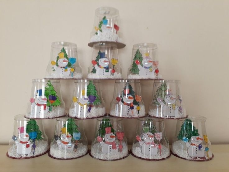 there are many glass cups that have snowmen and christmas trees on them in the shape of santa's sleighs