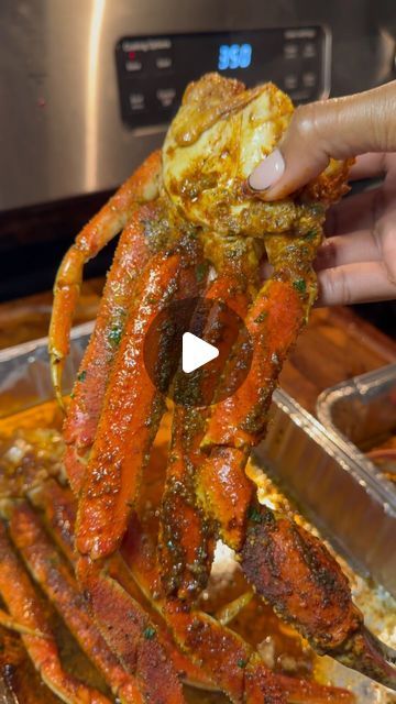 someone is holding up a cooked crab in front of an instant pot roasting machine