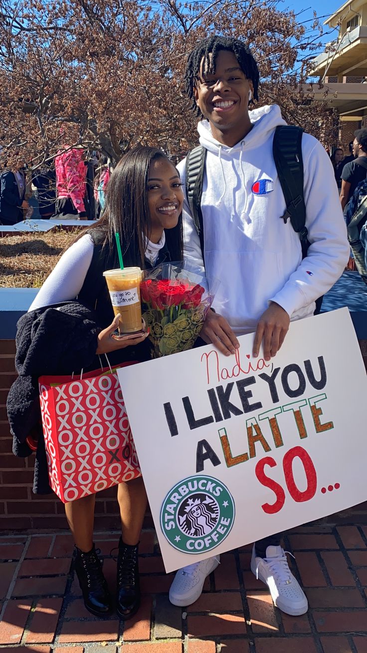 two people holding a sign that says i like you, atlanta so with starbucks coffee in front of them