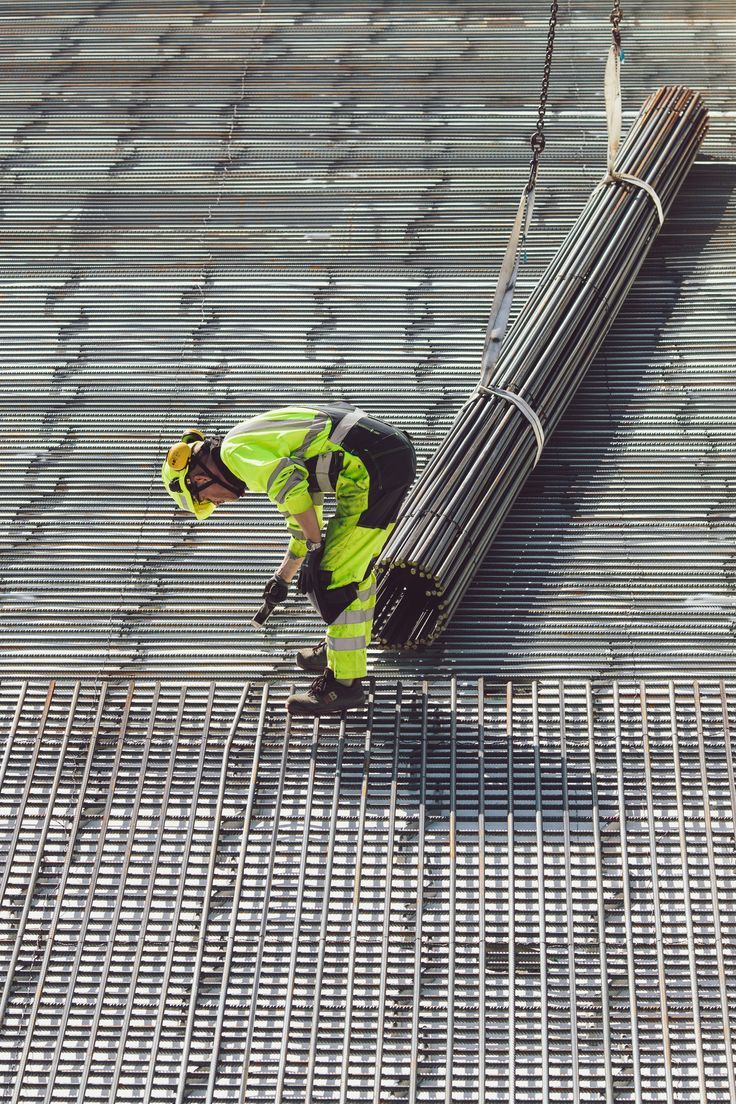 a construction worker working on the roof of a building with metal grates around it