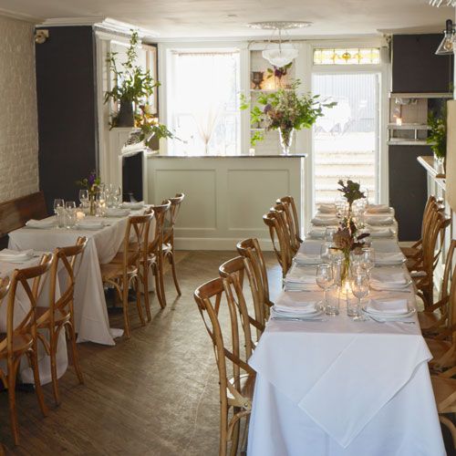 the dining room is set up with white tablecloths