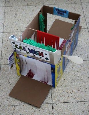 an open cardboard box on the ground with papers in it