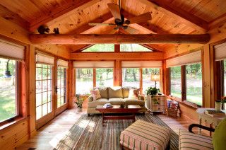 a living room filled with lots of furniture and windows covered in wooden shinnings