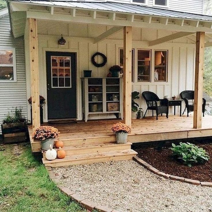 a small white house with porch and steps leading up to the front door, covered in wood