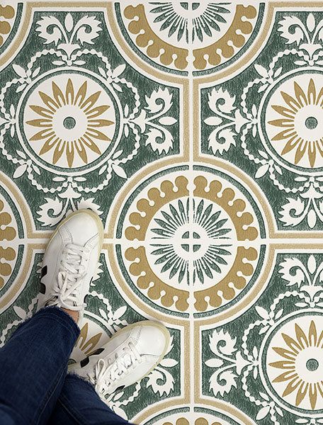 a person standing on the floor with their feet up in front of a tile pattern