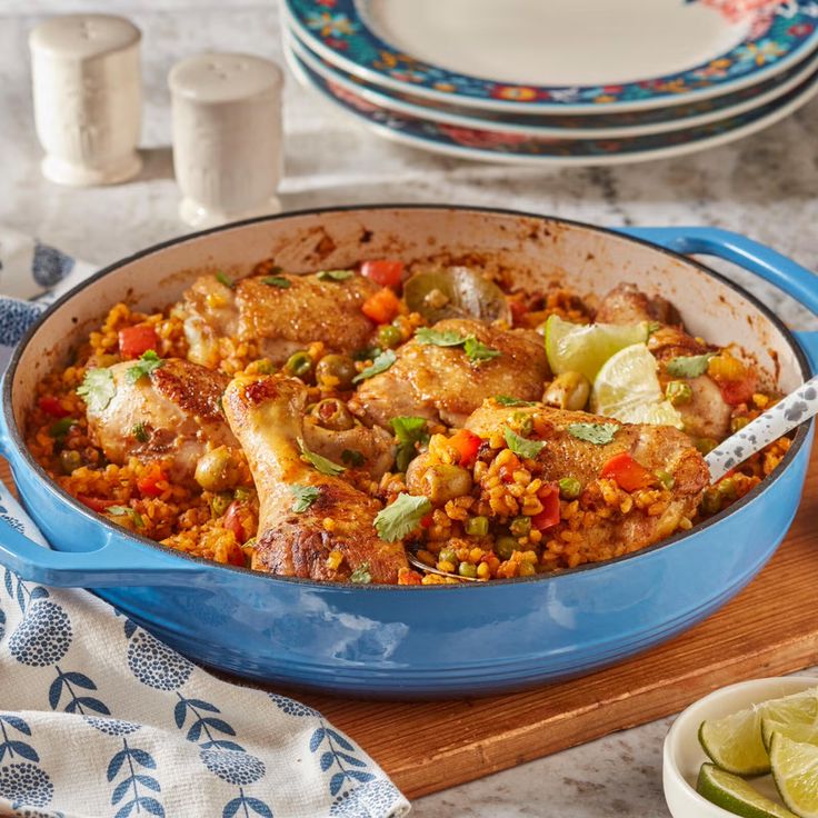 a blue casserole dish filled with chicken and vegetables