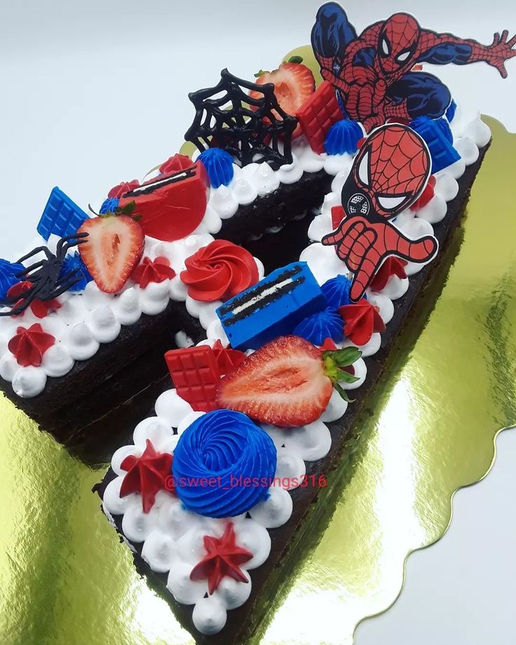 a piece of cake decorated with strawberries and spiderman decorations