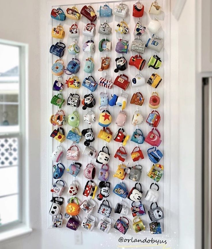 a wall mounted with many different kinds of magnets on it's side, in front of a window