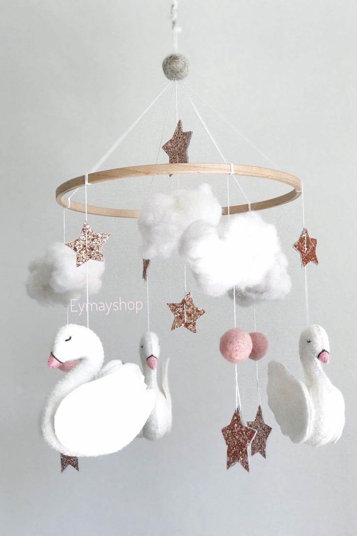 a white swan mobile with stars and clouds